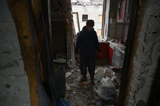 Un résident local se tient parmi les éclats de son appartement